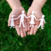 hands holding paper cutout of family
