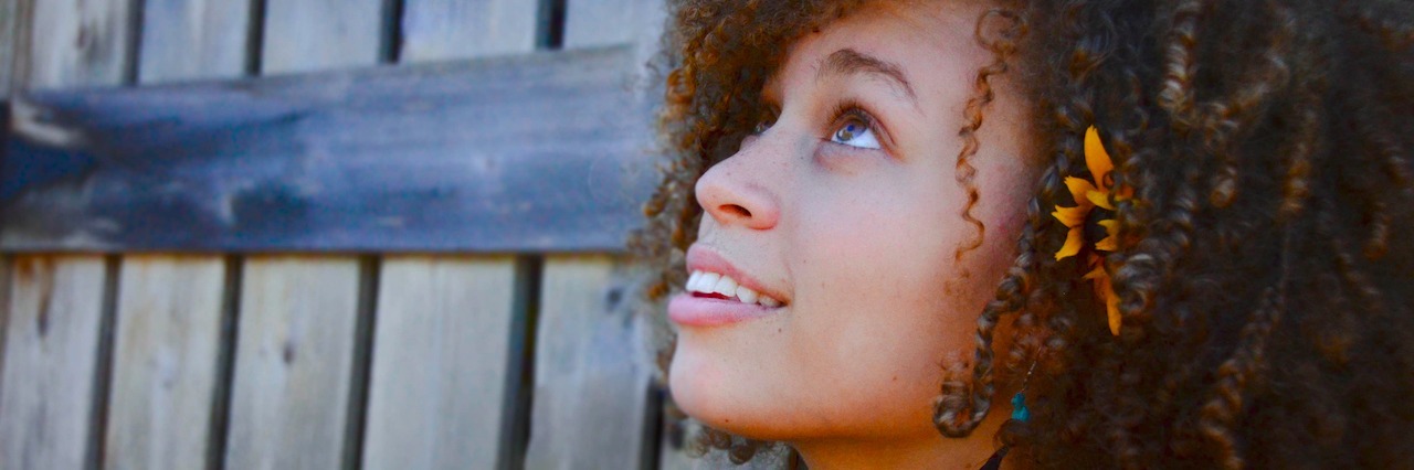 Girl with a flower in her hair looking up