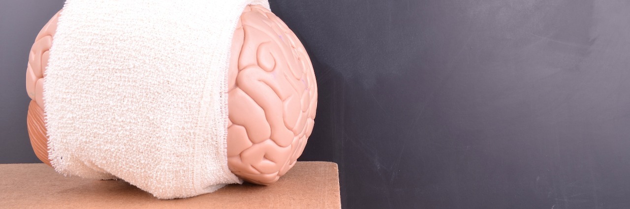 a model brain wrapped in a white bandage