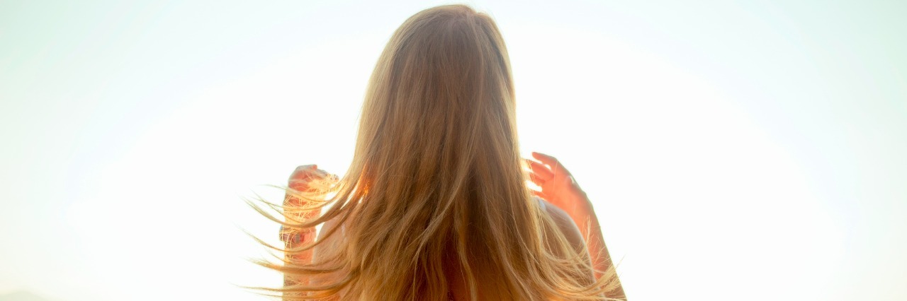 blonde woman looking over a lake