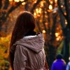 Girl in autumn park in front of sunset
