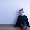 teenage girl sitting against wall