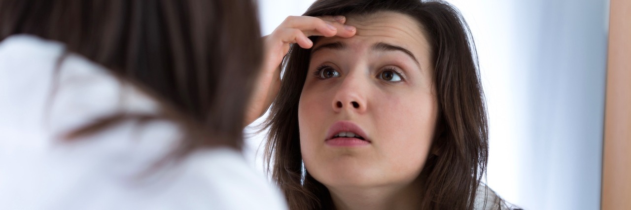 girl looking herself in the mirror