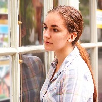 Disappointed Young Woman Looking In Window