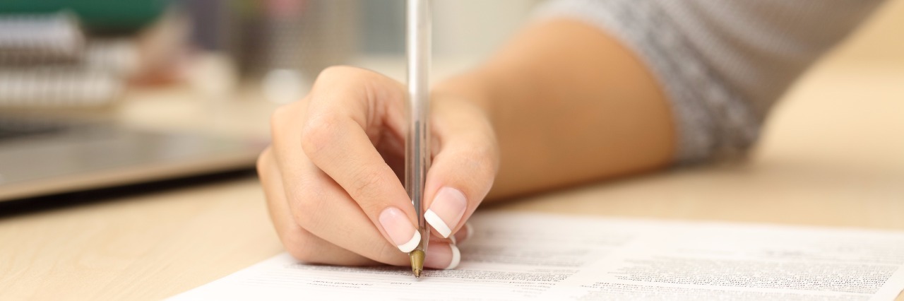 'Letters Against Depression' Helps People With Mental Illness Close up of a woman hand writing or signing in a document on a desk at home or office