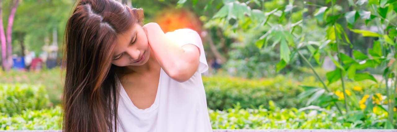 The ABCs of Truths About Chronic Pain Asian girl reading tablet with shoulder and neck pain