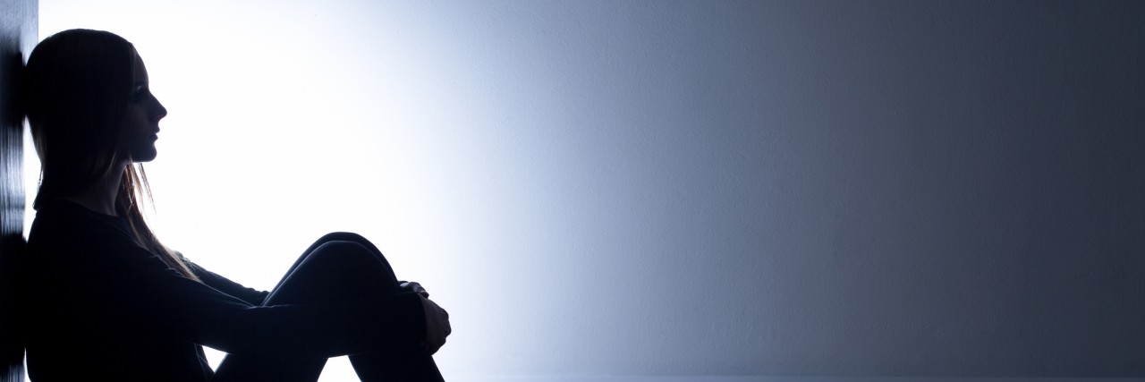 Coping With the Numbness and Nothingness That Comes With Depression Teenager with depression sitting alone in dark room