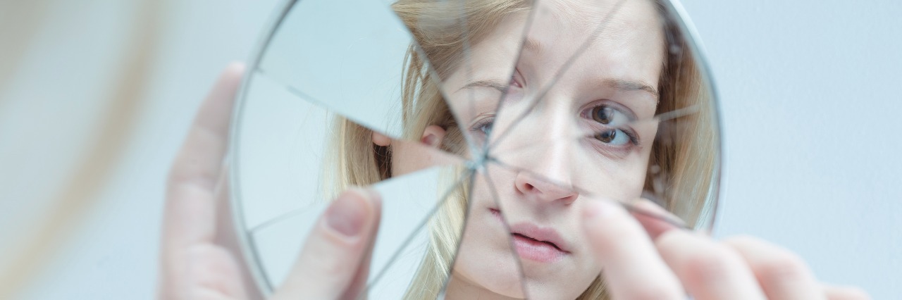 When Your Eating Disorder Tells You It's Trying to Help You Girl looking in cracked mirror