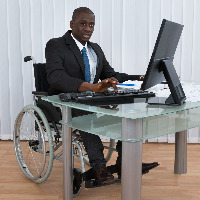 Man in a wheelchair working in an office.