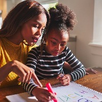 little black girl learning to write the alphabet with her mother