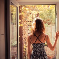 woman standing in a doorway looking outside