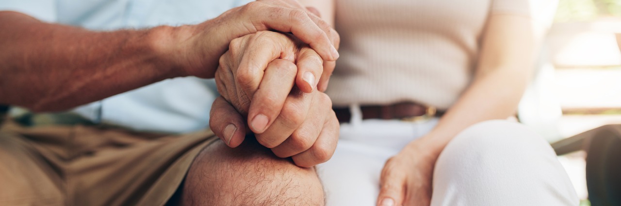 Living With a Husband or Wife Who Has Chronic Pain husband and wife sitting next to each other and holding hands