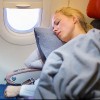 Lady traveling napping on a plane.
