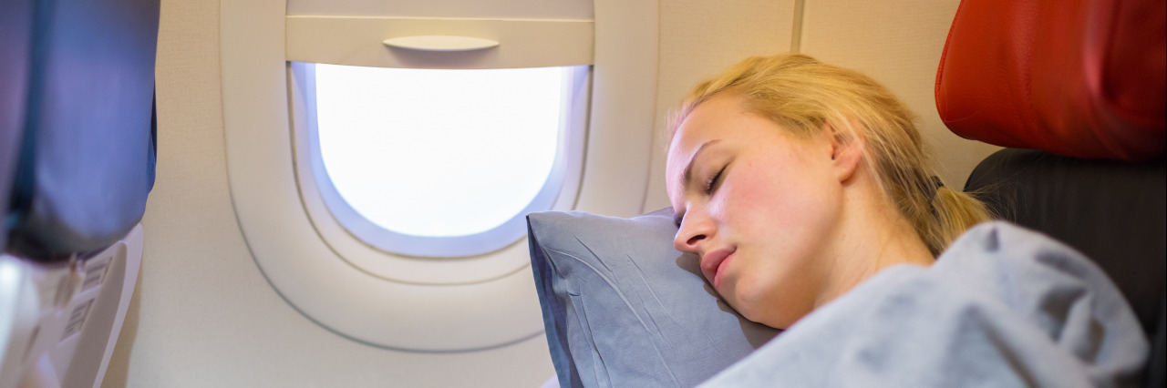 Tips for Air Travel With Scoliosis Lady traveling napping on a plane.