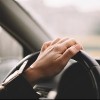 Hand on steering wheel while driving a car