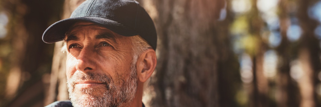 Senior man sitting in woods on a summer day