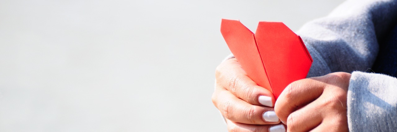Hands Holding a Red Heart Shape Paper