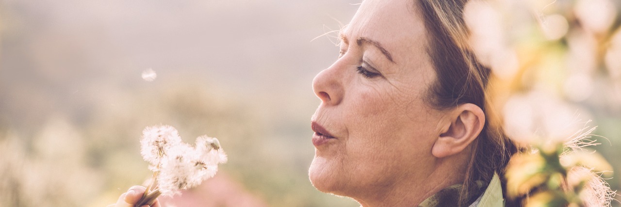 Mature woman with dandelion