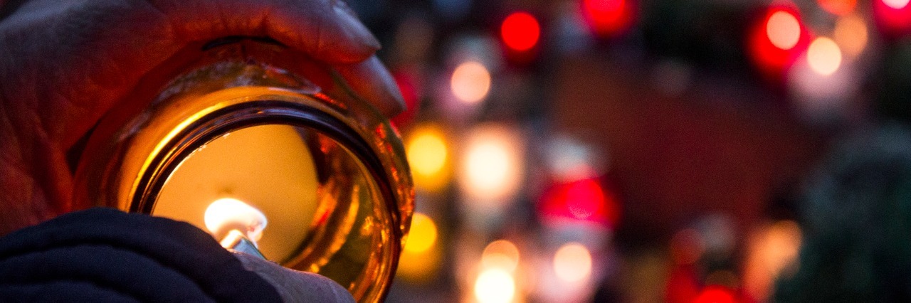 When Young People Pass Away From Fatal Disease female lighting candle to put on a grave