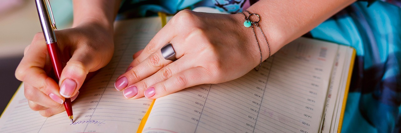 When I Realized My Eating Disorder Was My Focus in 2016 a woman writing in a calendar
