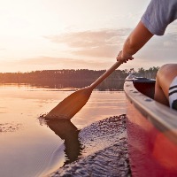 Woman canoeing at sunset on Jackfish Lake, Manitoba.