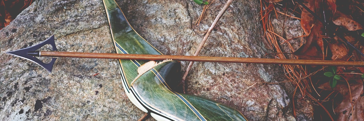 A bow and arrow placed on a rock