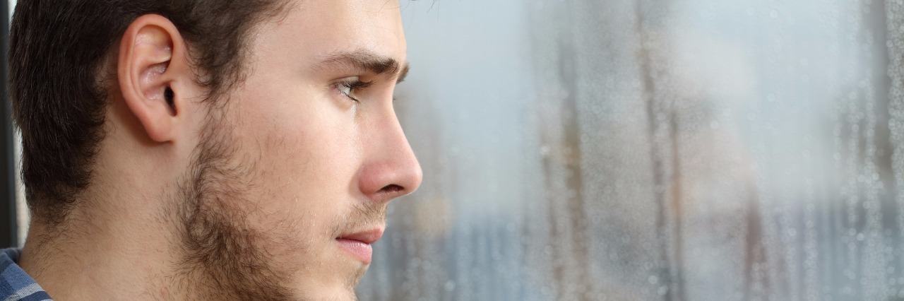 man longing and looking through window