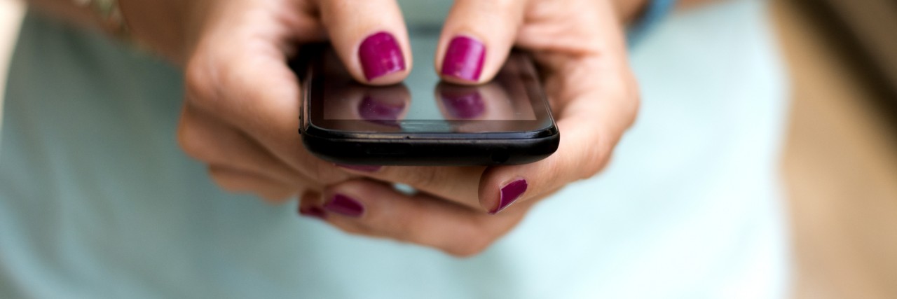 What to Do When Reaching Out to a Friend About Being Suicidal Girl holding smart phone outside