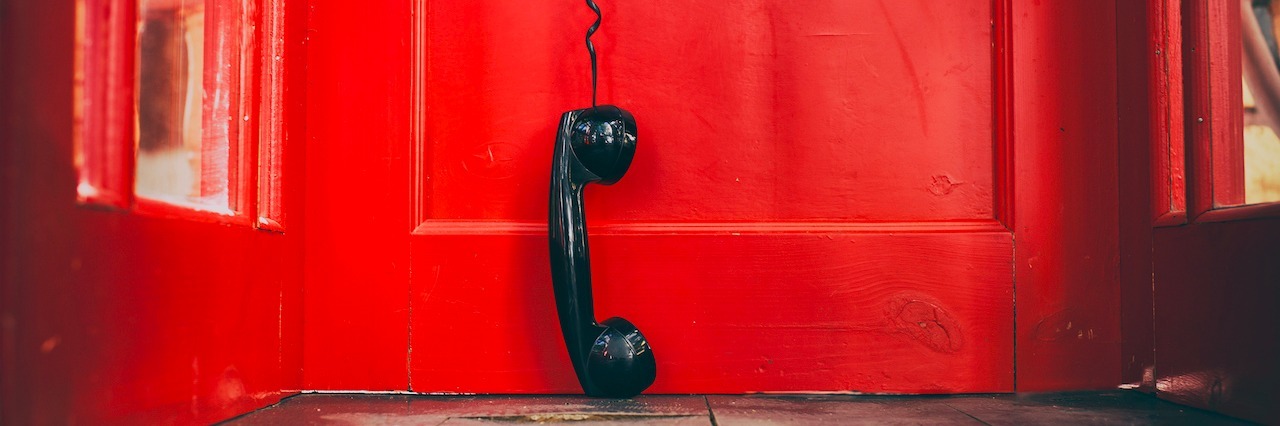 How Switchboard Miami Saved My Life When I Was Suicidal a phone hanging from a phone booth
