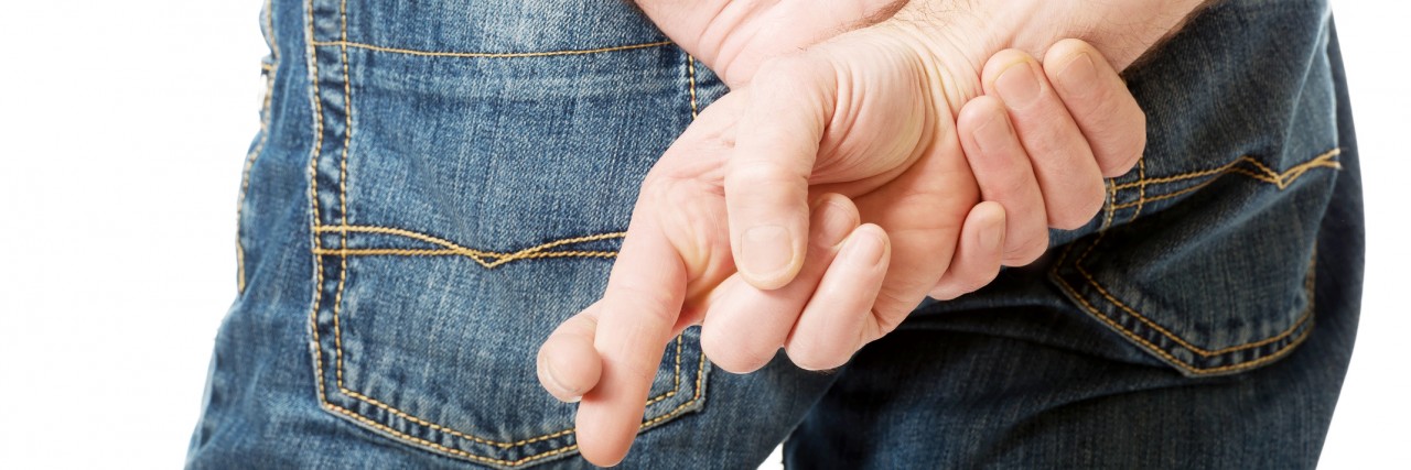 Close up on a man with crossed fingers.