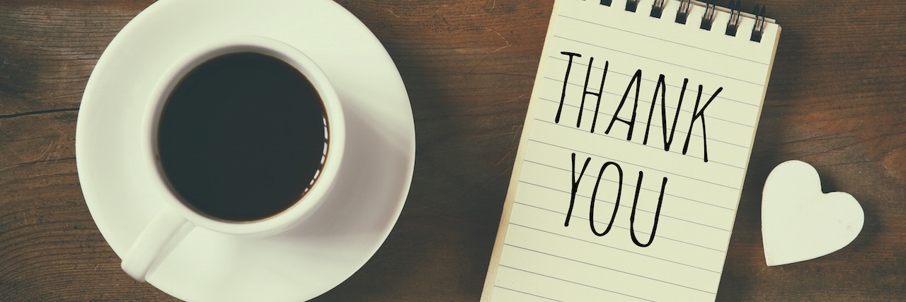 notebook that reads Thank You next to a cup of coffee