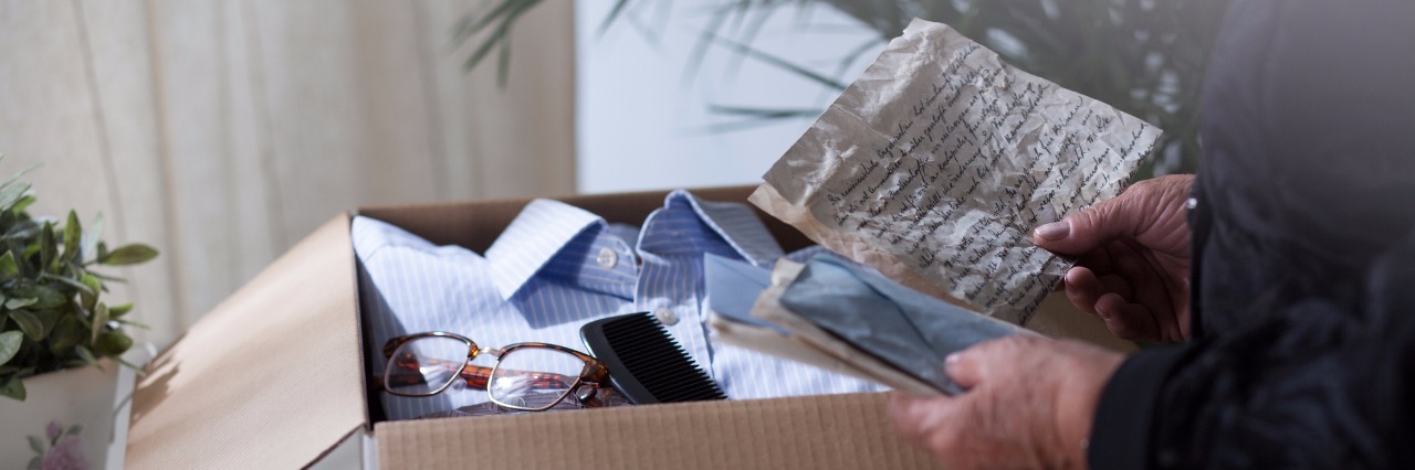 Gift From Late Father Helps Daughter Cope With Grief woman is reading old letters before putting it away in a box