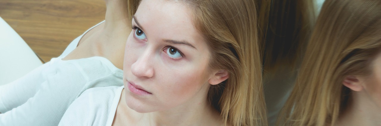 How to Support a Loved One During a Psychotic Episode woman sitting on floor surrounded by mirrors