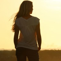 Rear view of young woman at sunset
