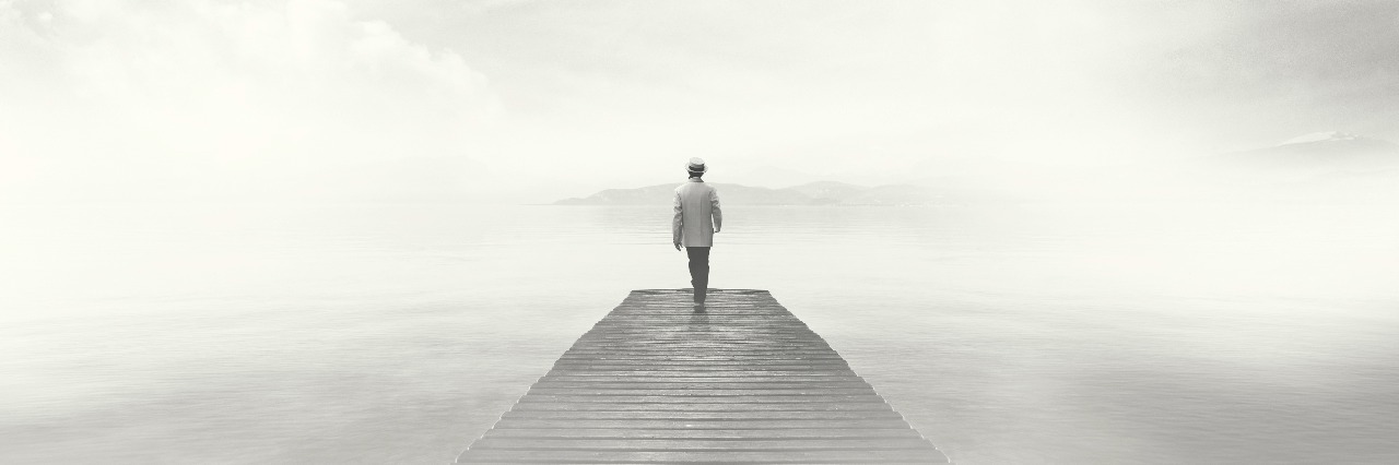 What Living With Depression Feels Like Man walking on a boardwalk in the fog