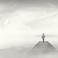Man walking on a boardwalk in the fog