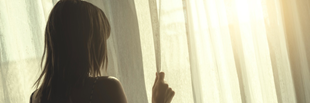 When I'm at My Breaking Point With My Illnesses Lonesome girl holding a curtain.