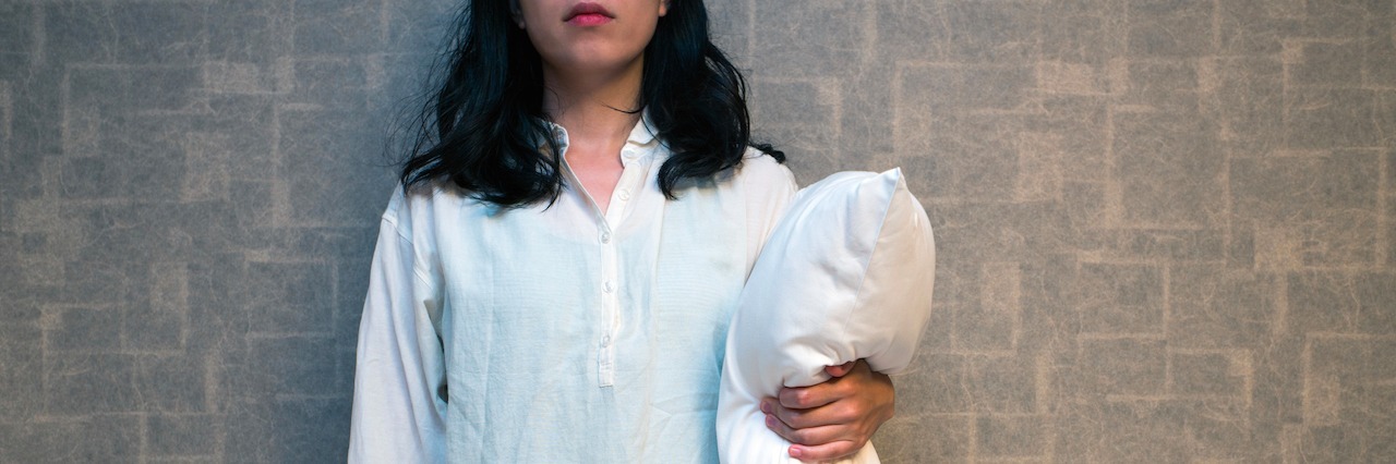 Conquering Insomnia By 'Embracing' the Beast woman holding a pillow