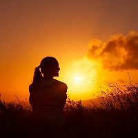 Woman watches the beautiful sunset/sunrise.