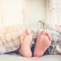 Close up feet of women sleeping on bed in Morning
