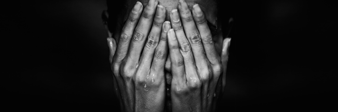 Dealing With Anger as a Suicide Survivor A woman crying, covering her face with her hands