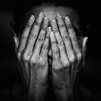 A woman crying, covering her face with her hands