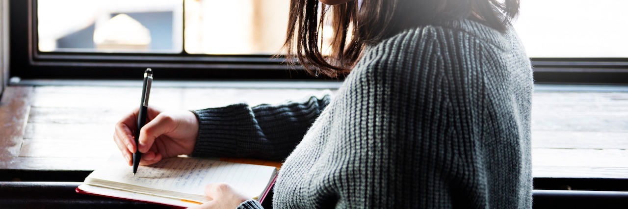 New Year's Resolutions for People With Borderline Personality Disorder woman writing in a notebook