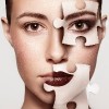 Woman with jigsaw puzzle pieces on face.