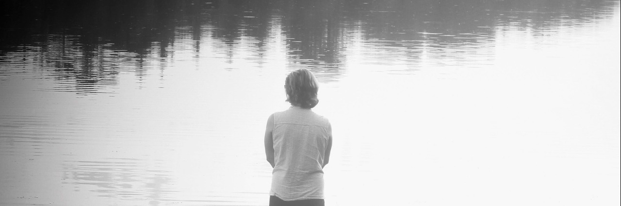The Pain Inside After Losing My Mother Woman standing in front of tree-lined lake