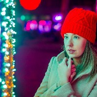 Lonely Christmas woman on the winter street at night.