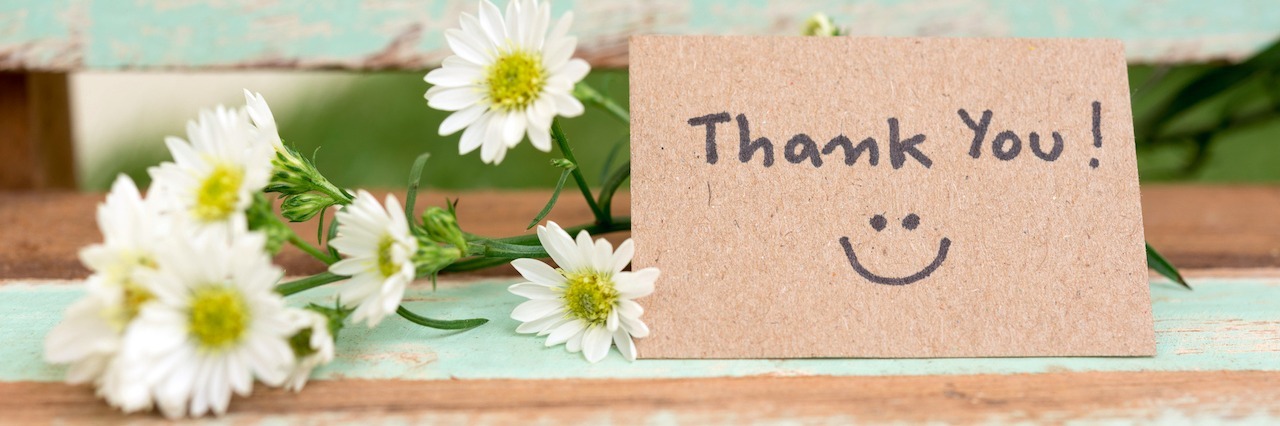 A Letter to All Mental Health Carers Thank you note with smile face and flower cluster on wooden chair