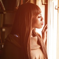 Black woman looking through the window.