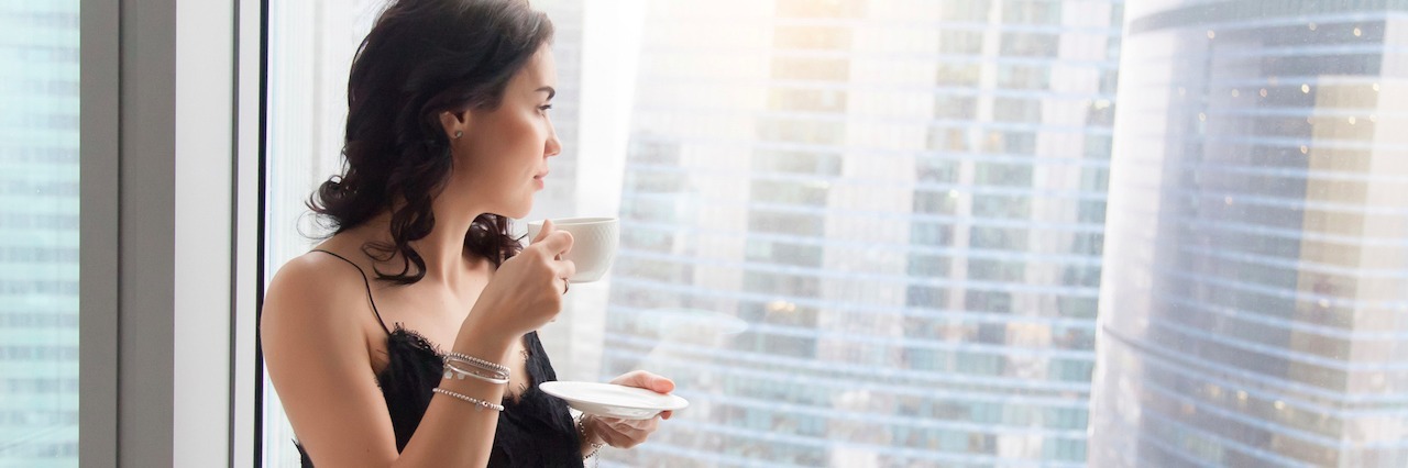 Mental Illness and Being the Girl Who Can Do Anything woman looking out the window, drinking tea