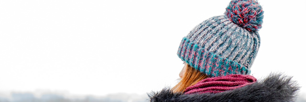 woman sitting on bench in snowy weather